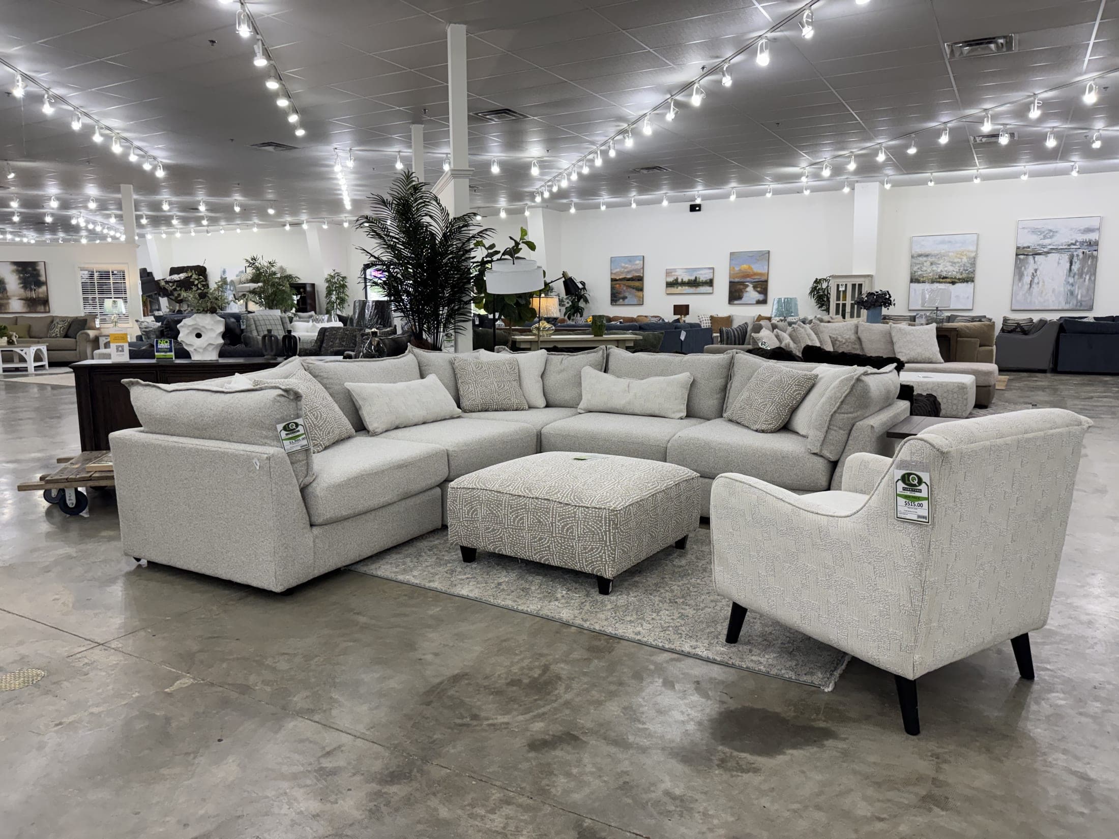 An oversized sectional on the LQ Furniture floor in Tupelo, string lights running deep into the warehouse behind it