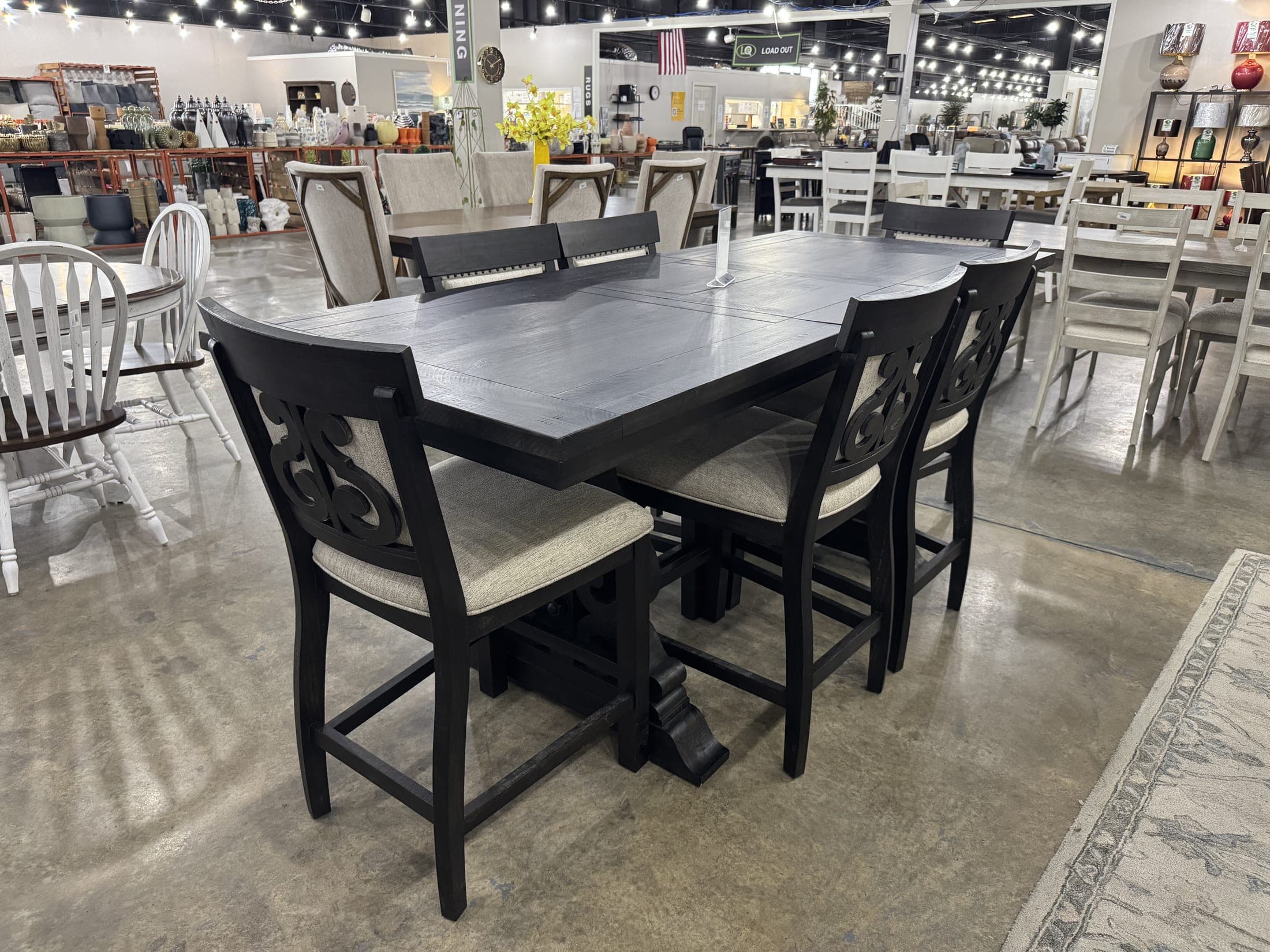 Black counter-height dining table with six upholstered chairs
