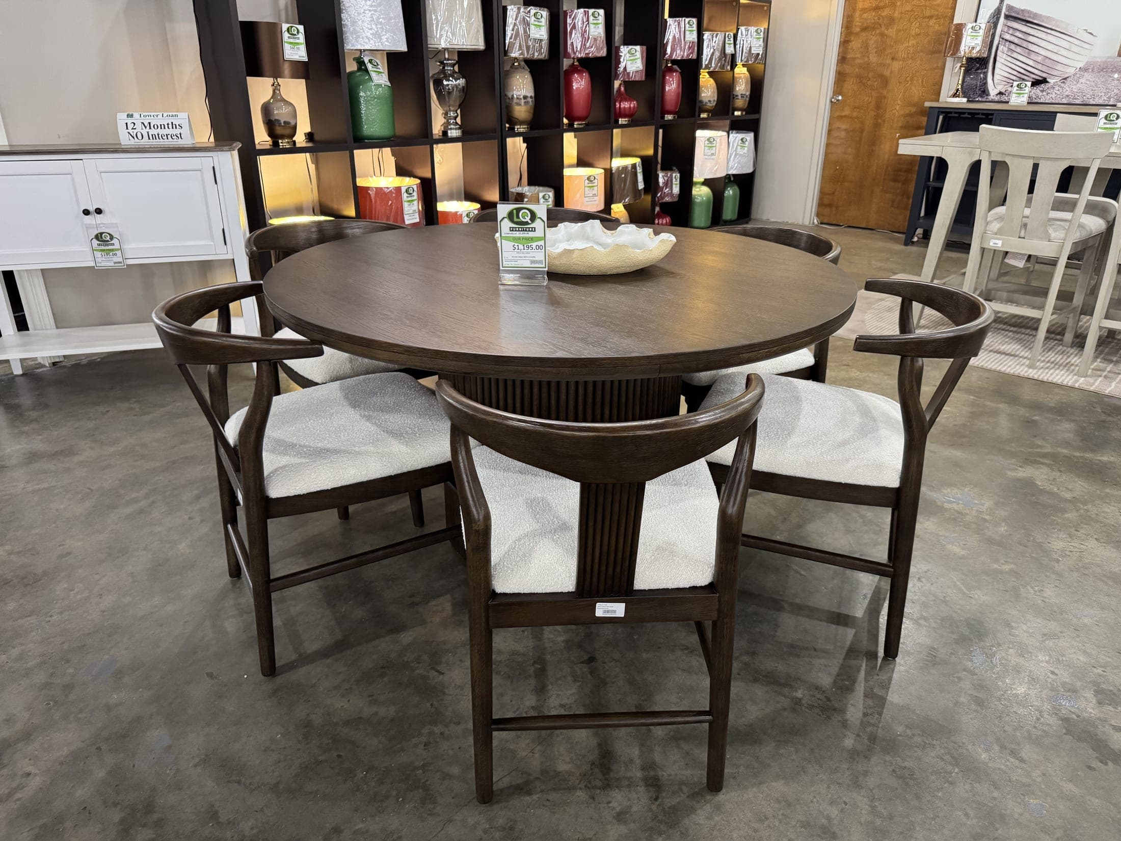 Round walnut dining table with cream upholstered chairs