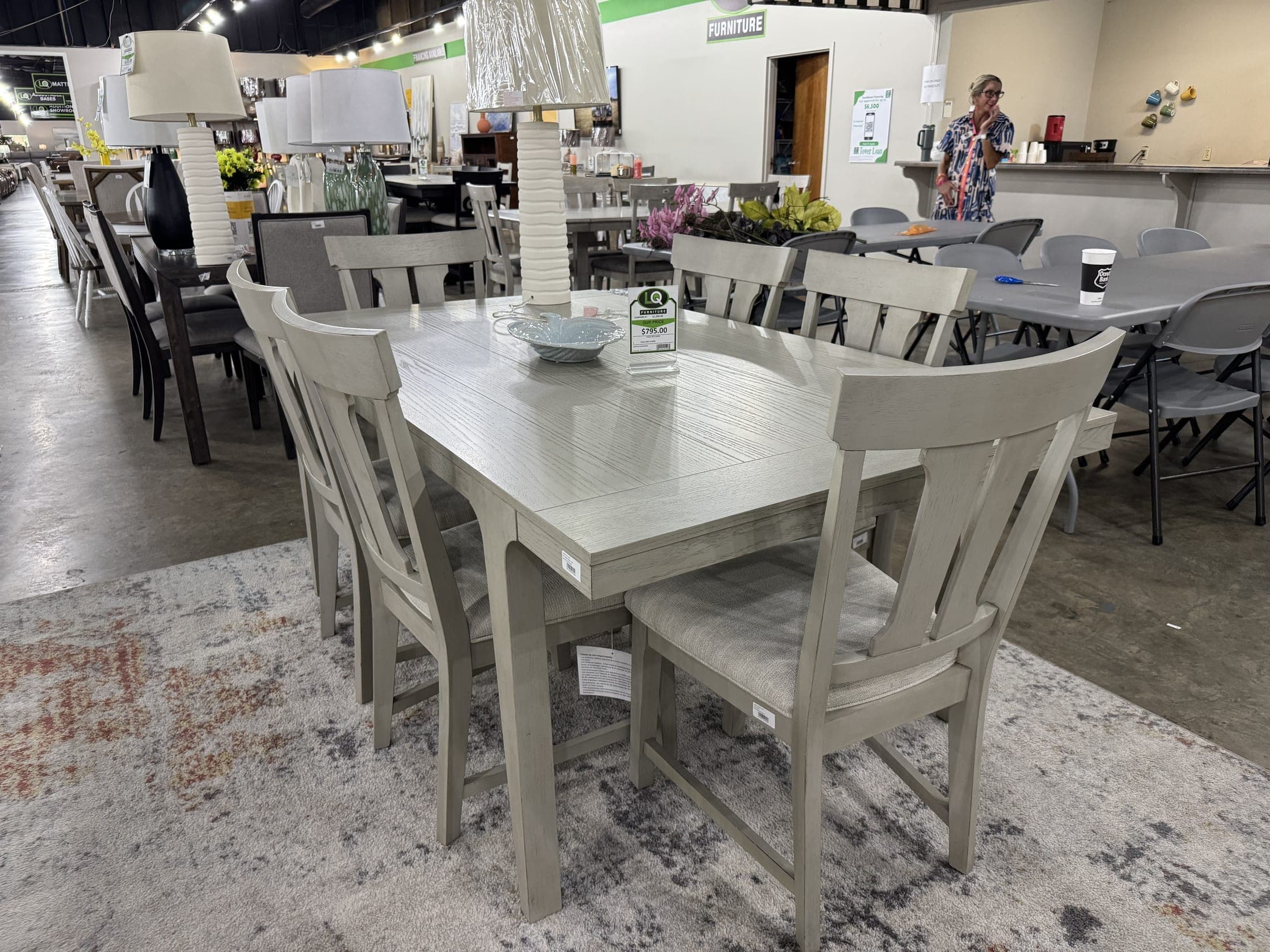 Whitewashed dining table with upholstered chairs on a rug