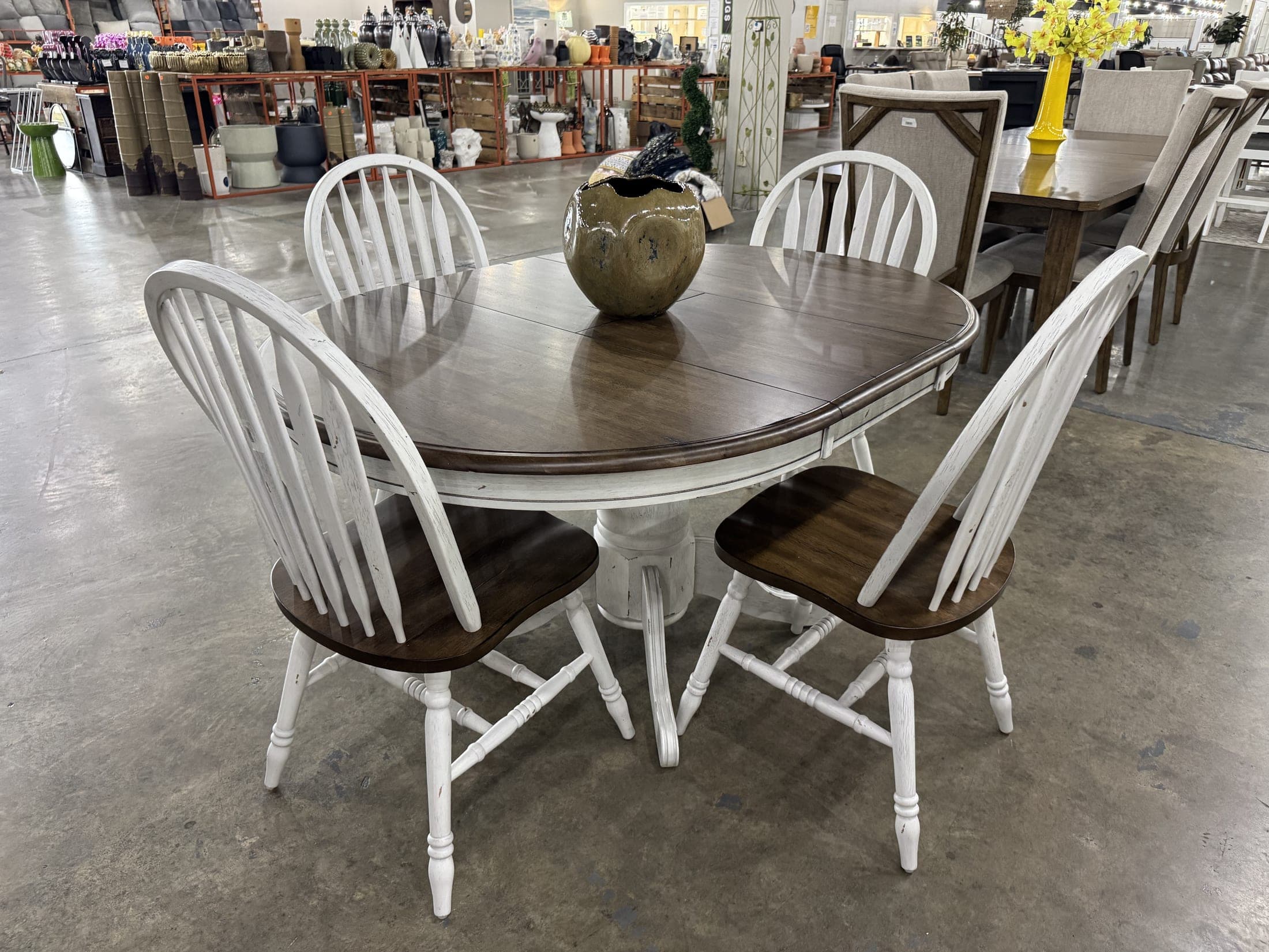 Round white pedestal table with spindle-back chairs