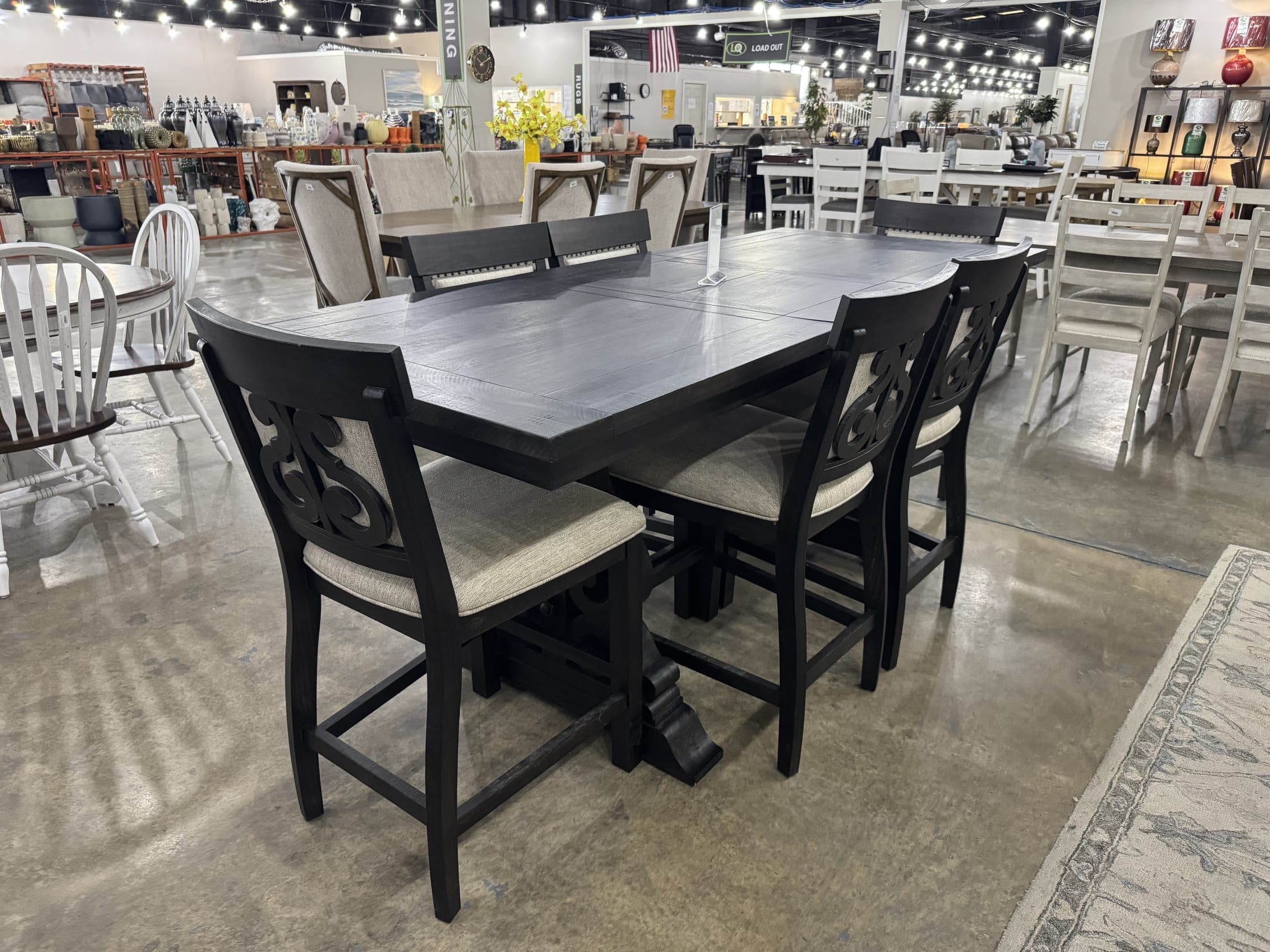 Black counter-height table with cushioned stools