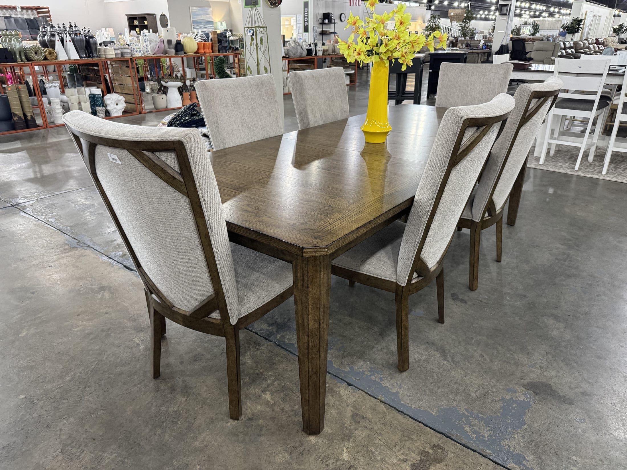 Dining table flanked by tall upholstered host chairs
