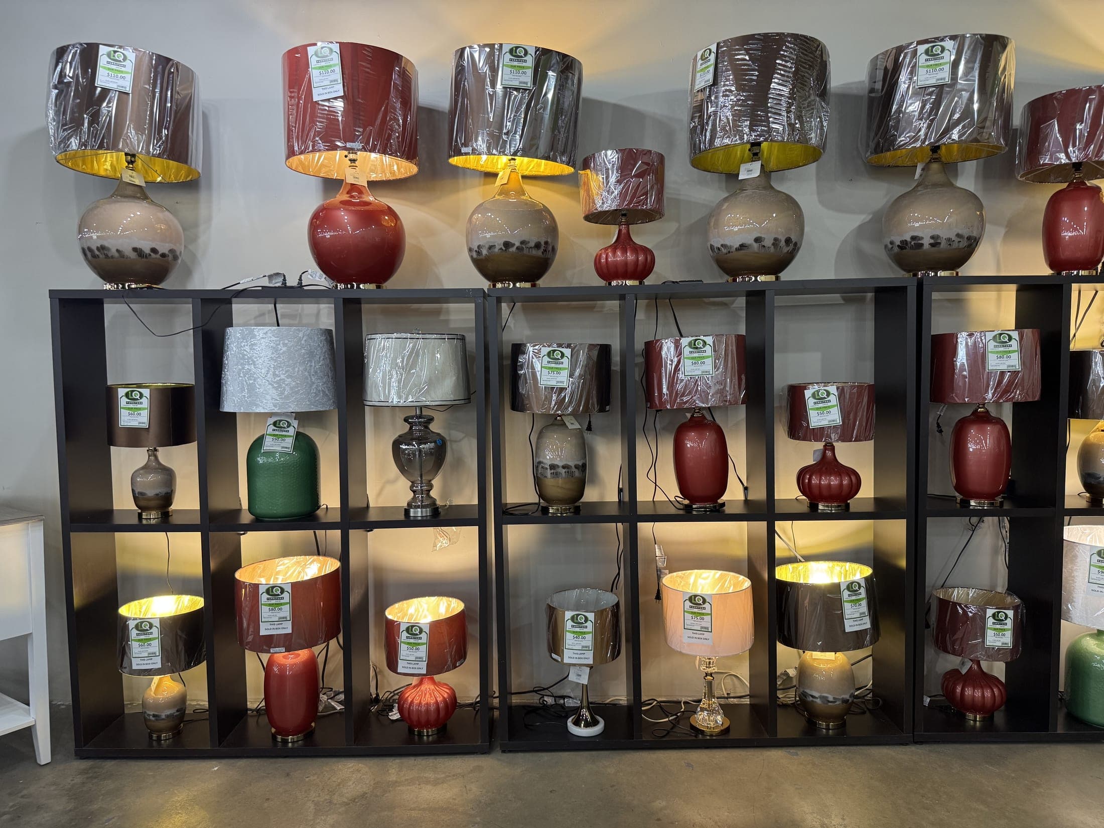 Shelving wall filled with table lamps in every color