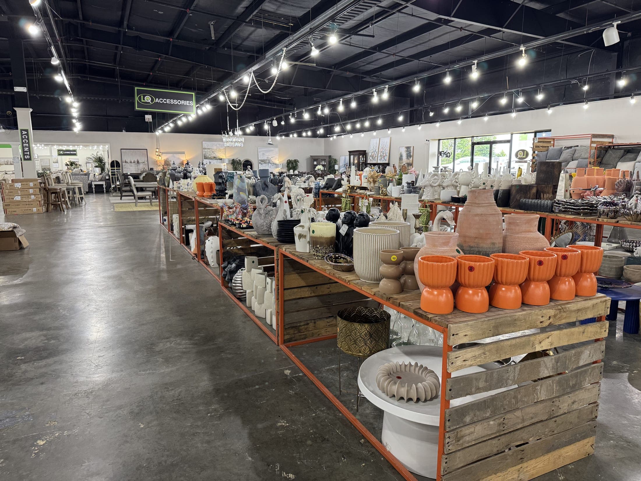 The accessories aisle at LQ Furniture, crate tables of lamps and decor under string lights