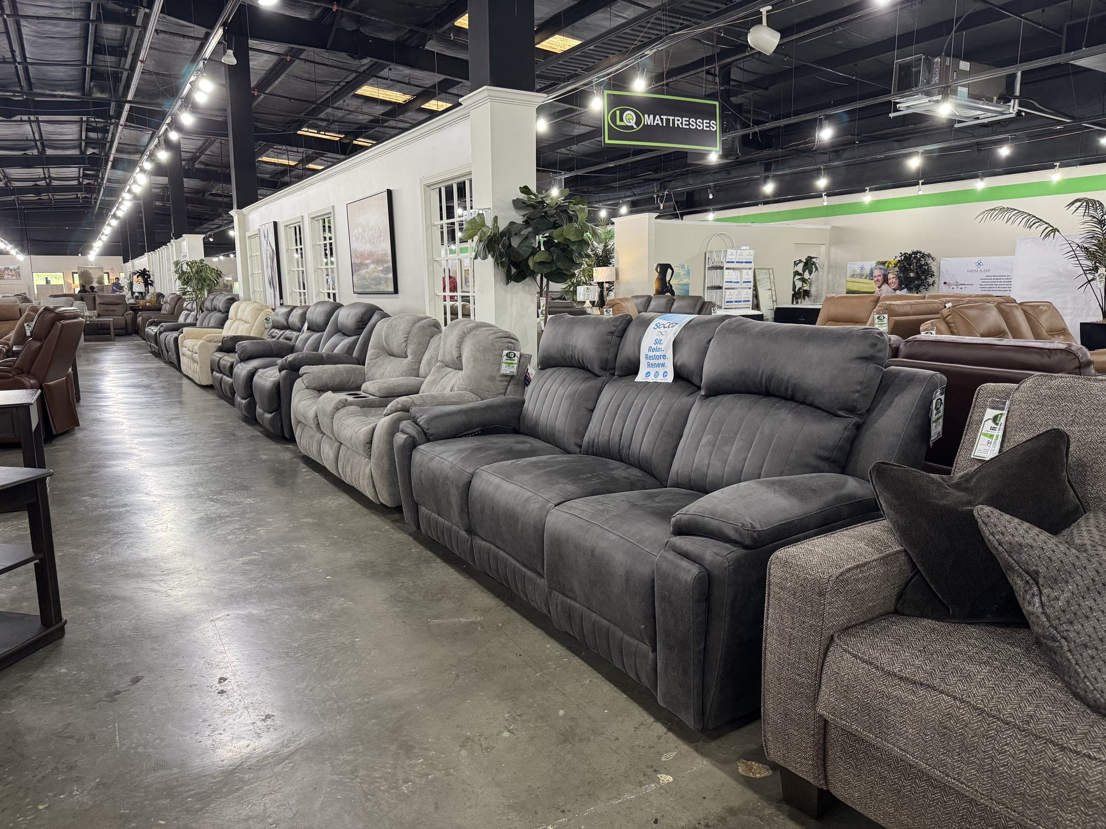 Rows of reclining sofas stretching toward the back of the LQ warehouse