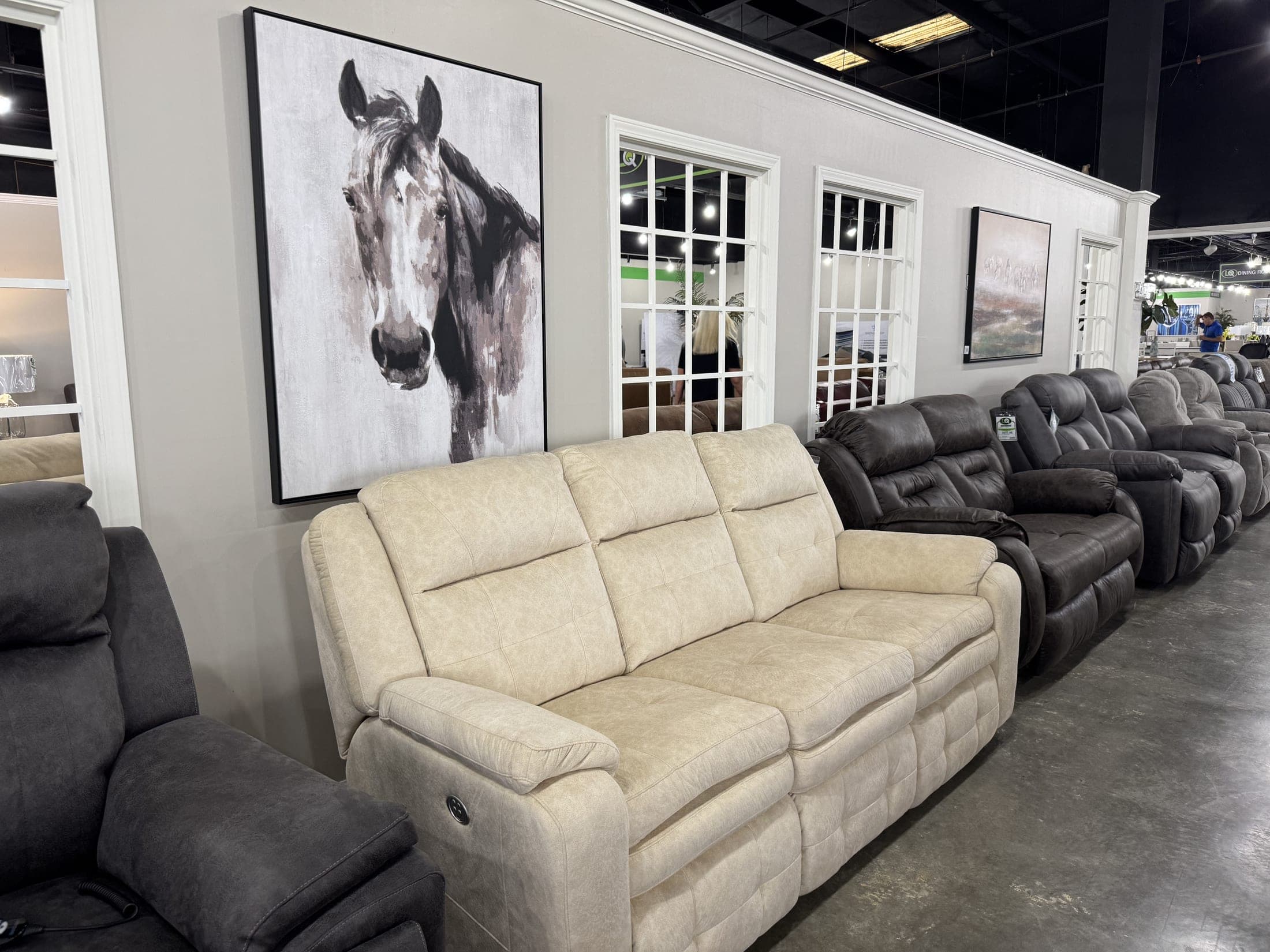 Cream power reclining sofa beneath a framed horse print