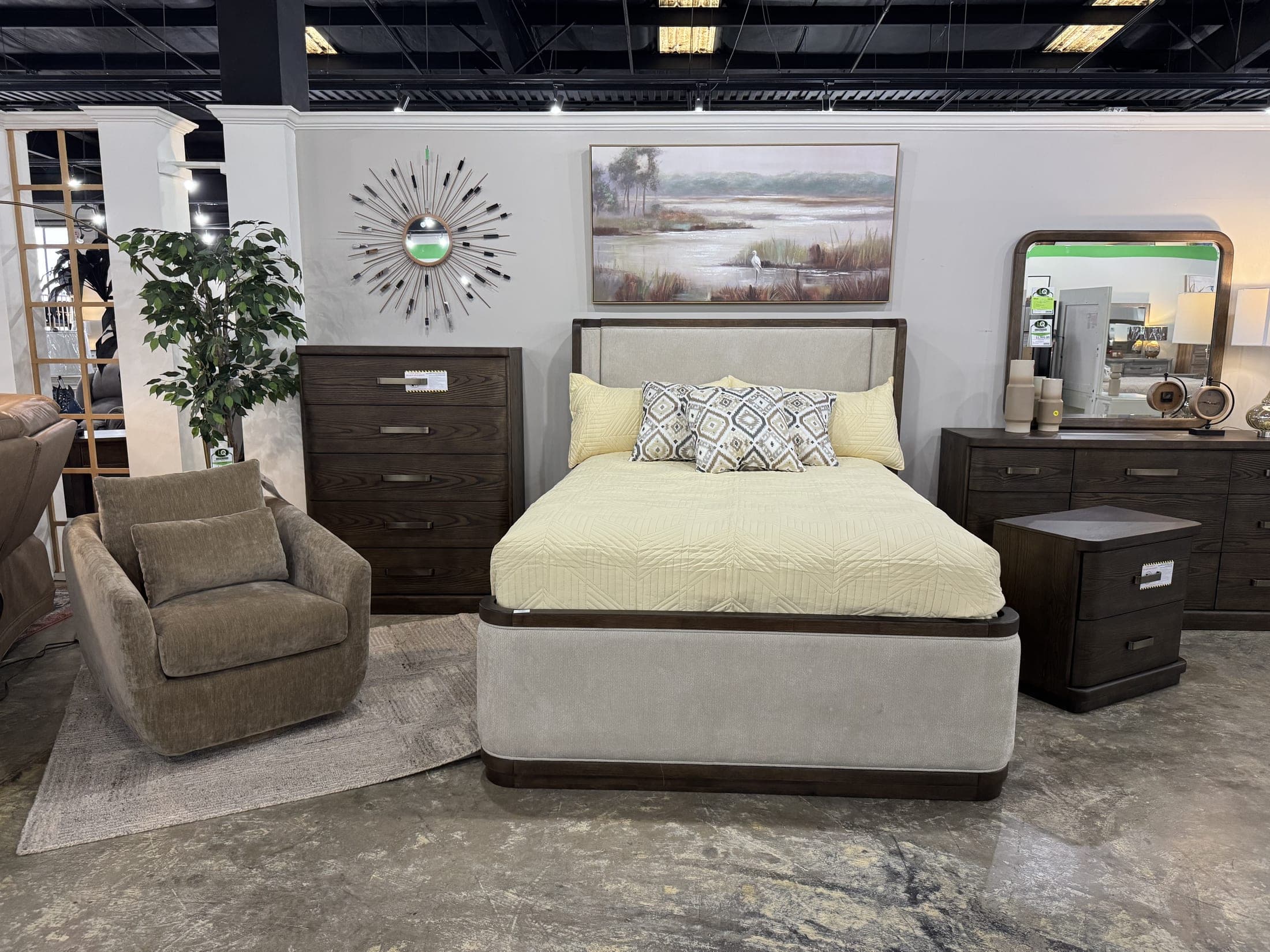 Upholstered bed with dark dresser and accent chair