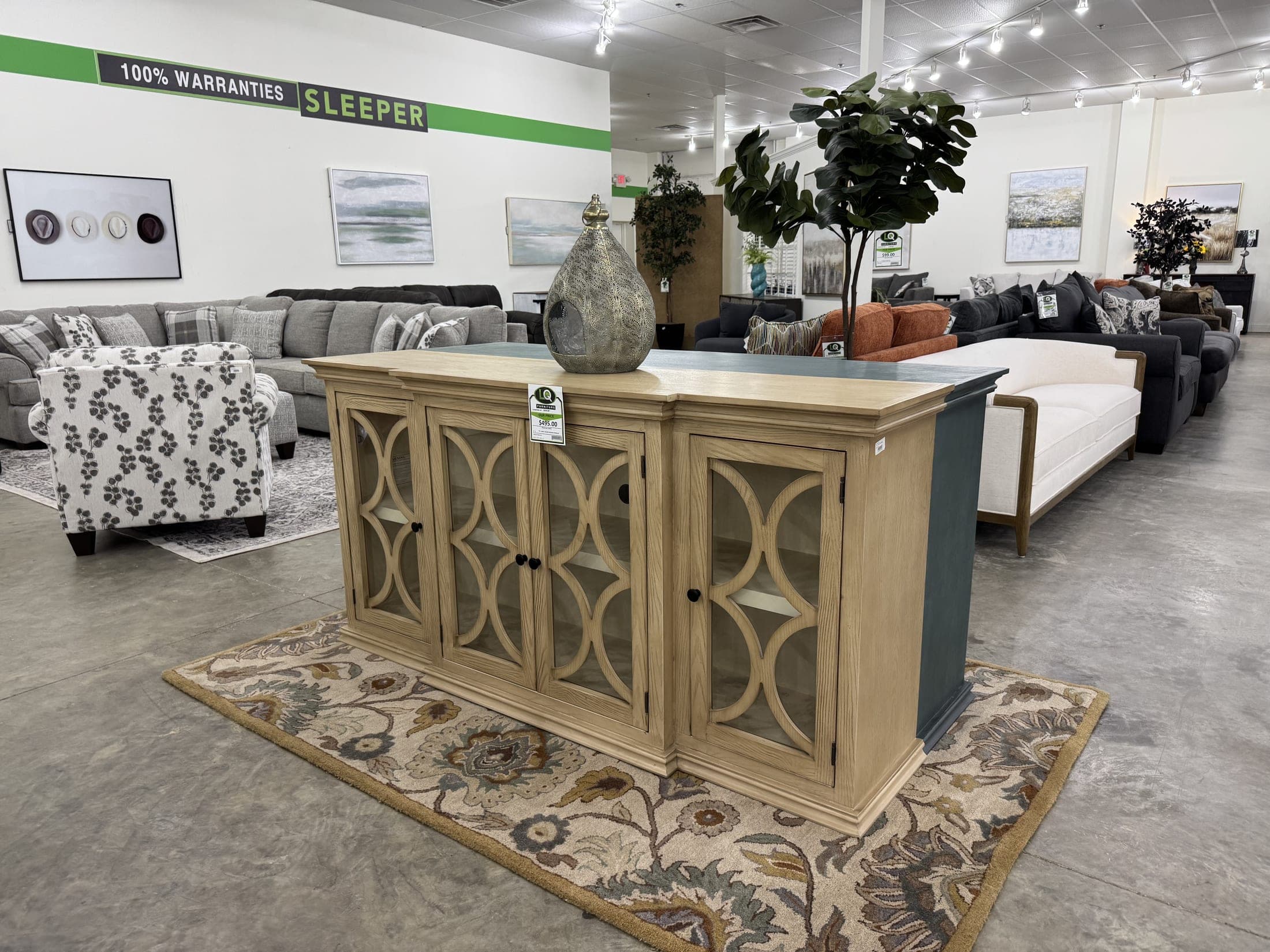 Accent cabinet with glass fretwork doors staged between sofas